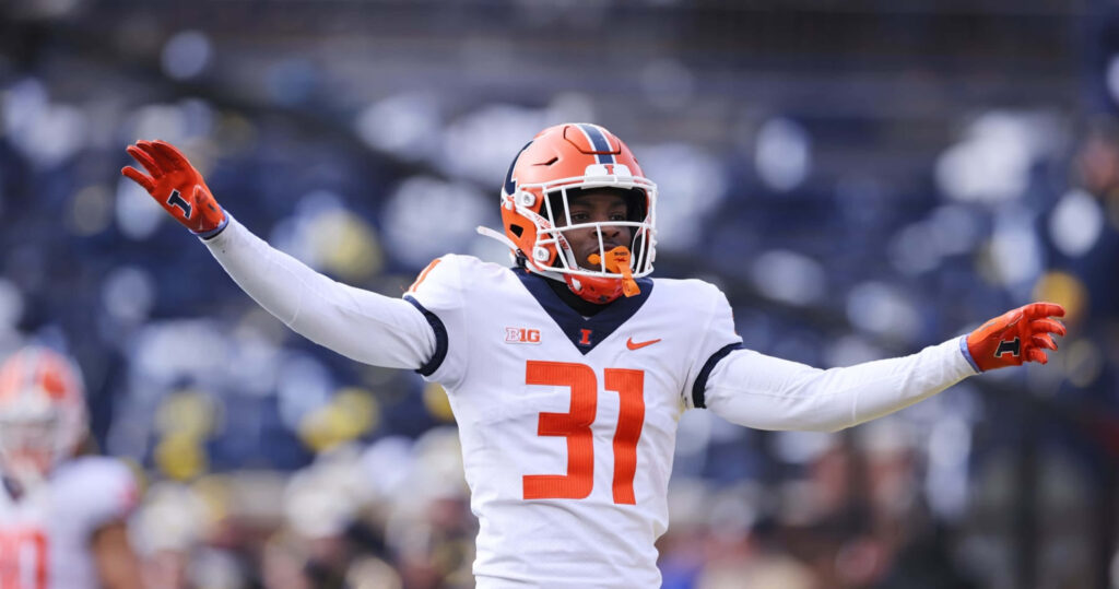 Devon Witherspoon in Illinois Fighting Illini uniform confident on football field with arms outstretched Wallpaper