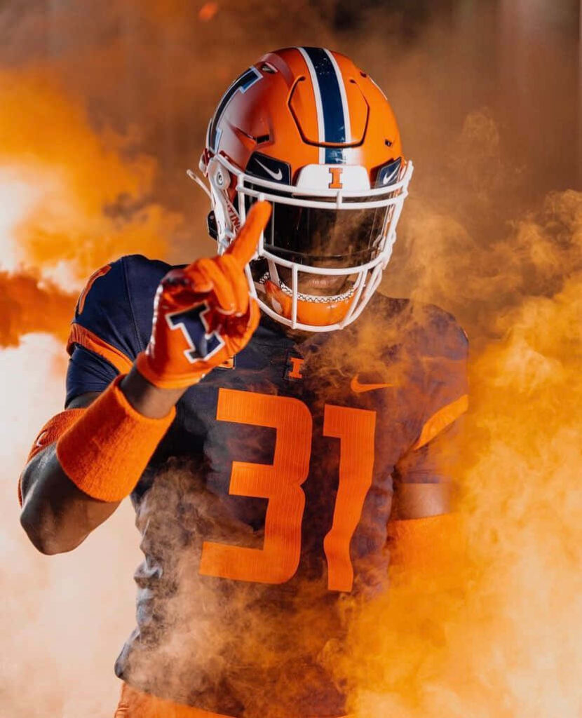 Devon Witherspoon in Illinois football uniform number 31 with vibrant orange smoke background Wallpaper