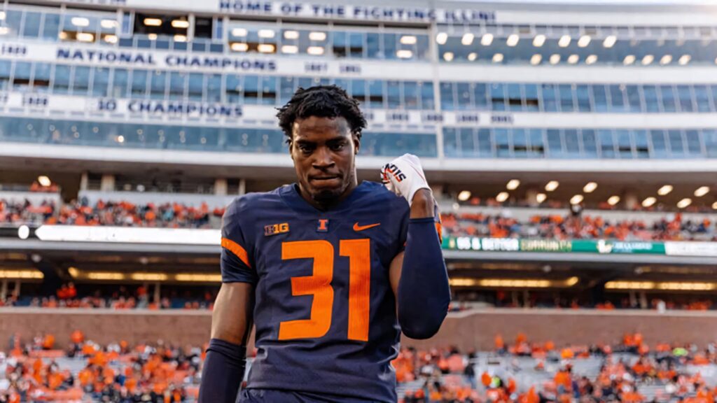 Devon Witherspoon in Illinois jersey 31 on football field with packed stadium and Illini banners Wallpaper