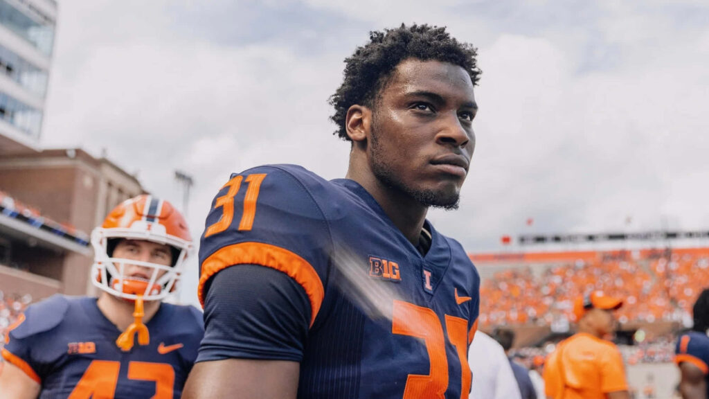 Devon Witherspoon in navy orange jersey number 31 focused on football field with stadium crowd Wallpaper