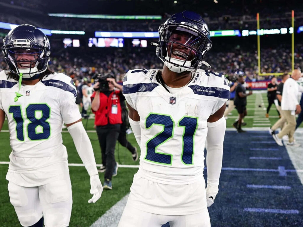 Devon Witherspoon celebrating in Seattle Seahawks uniform under bright stadium lights game night energy Wallpaper
