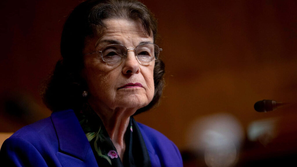 Dianne Feinstein formal portrait warm lighting royal blue blazer classic eyeglasses public service Wallpaper