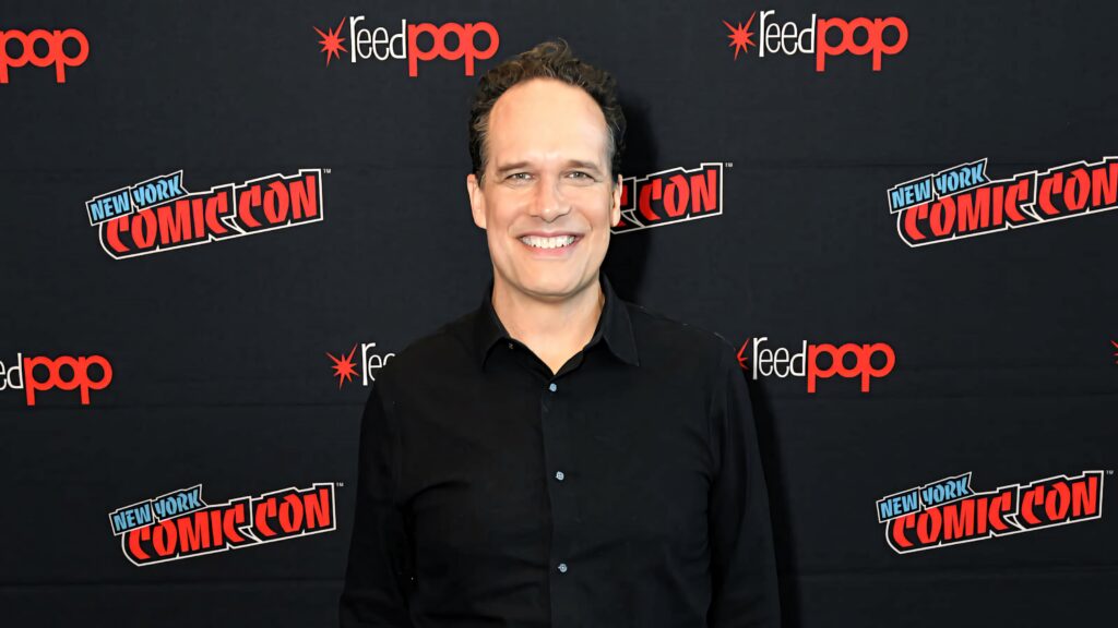 Award-winning actor Diedrich Bader smiling close-up at New York Comic Con in black shirt bright lighting Wallpaper