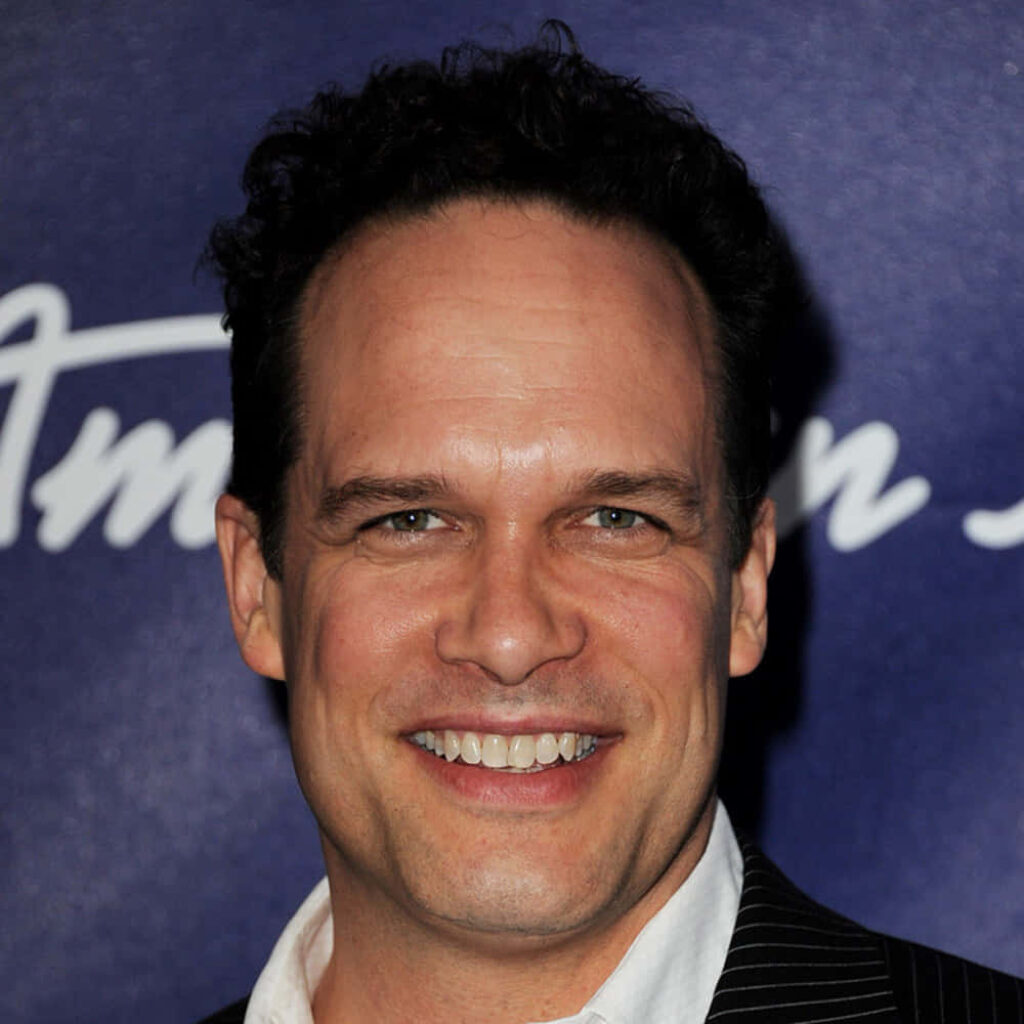 Diedrich Bader smiling warmly against deep blue background vivid lighting charismatic portrait Wallpaper