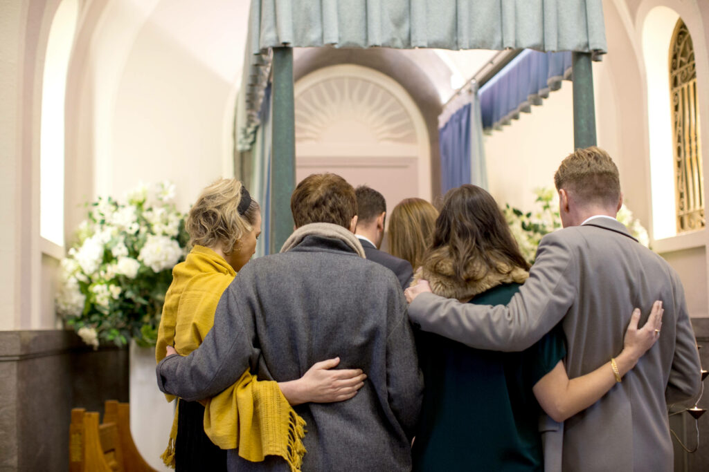 Gathering of Bereaved: A Solemn Farewell at the Funeral Wallpaper