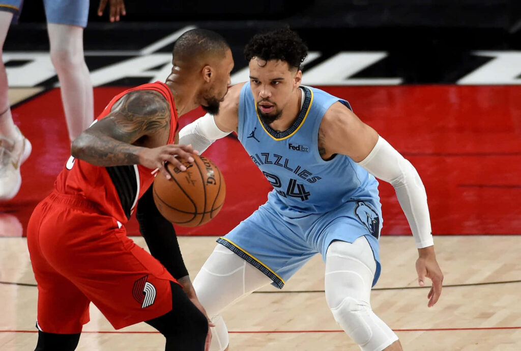Dillon Brooks in light blue jersey guarding Damian Lillard red jersey intense basketball action Wallpaper