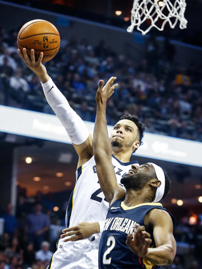 Dillon Brooks drives to basket against Ian Clark intense basketball action under bright arena lights Wallpaper