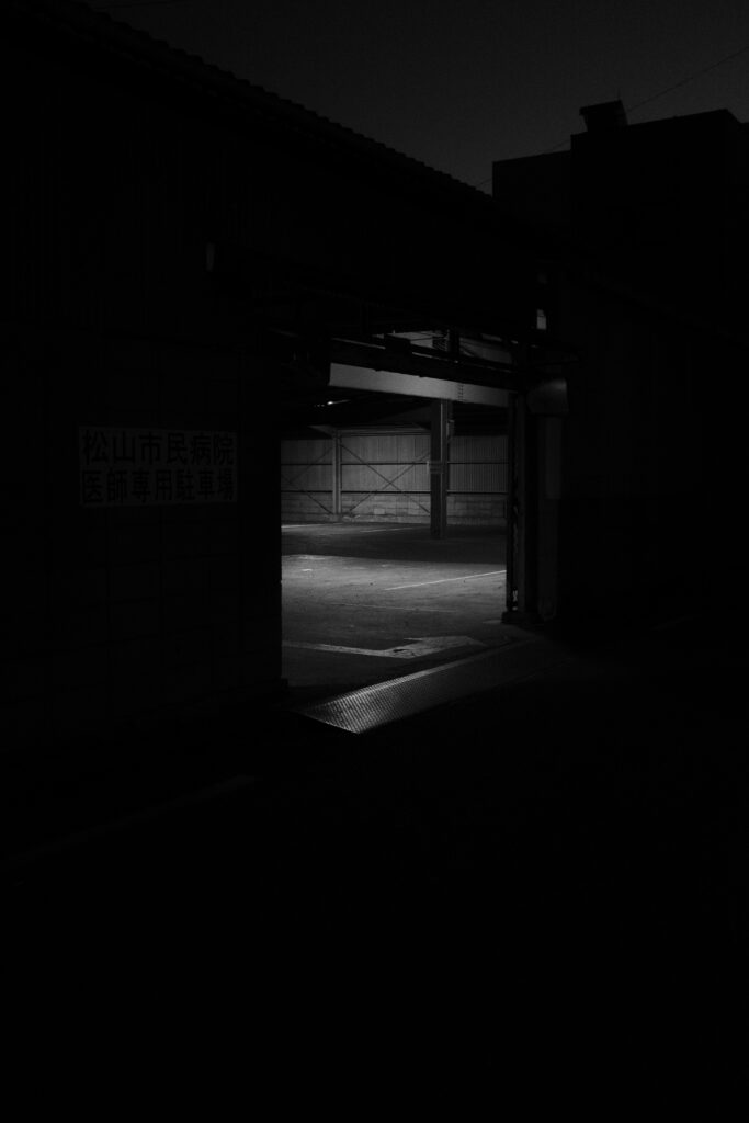 Moody Night Scene: Dim Building & Serene Parking Area Wallpaper