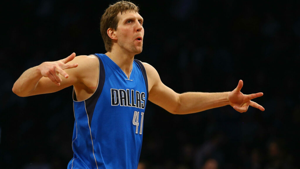 Dirk Nowitzki in blue Mavericks jersey celebrates three-pointer with intense focus on court Wallpaper