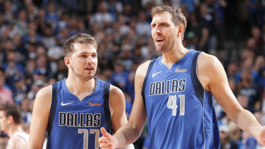 Dirk Nowitzki and Luka Doncic in blue Dallas Mavericks jerseys in vibrant NBA arena background Wallpaper