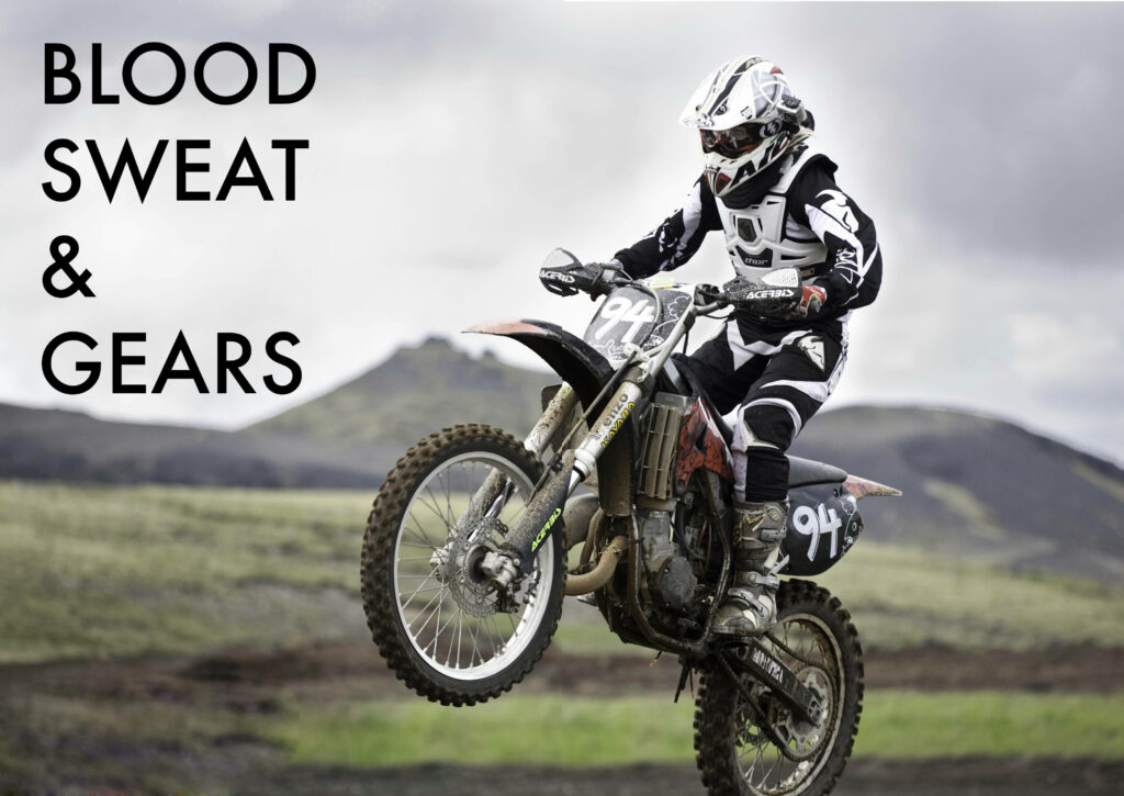 Motocross rider doing wheelie on rugged dirt trail with dramatic clouds and Blood Sweat Gears text Wallpaper