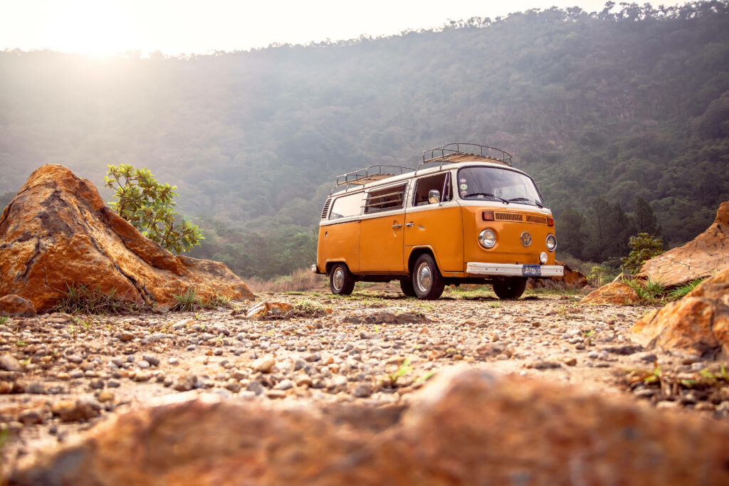 Roaming Adventures: Capturing Joyful Moments with a Sunlit Yellow Van on a Scenic Path Wallpaper