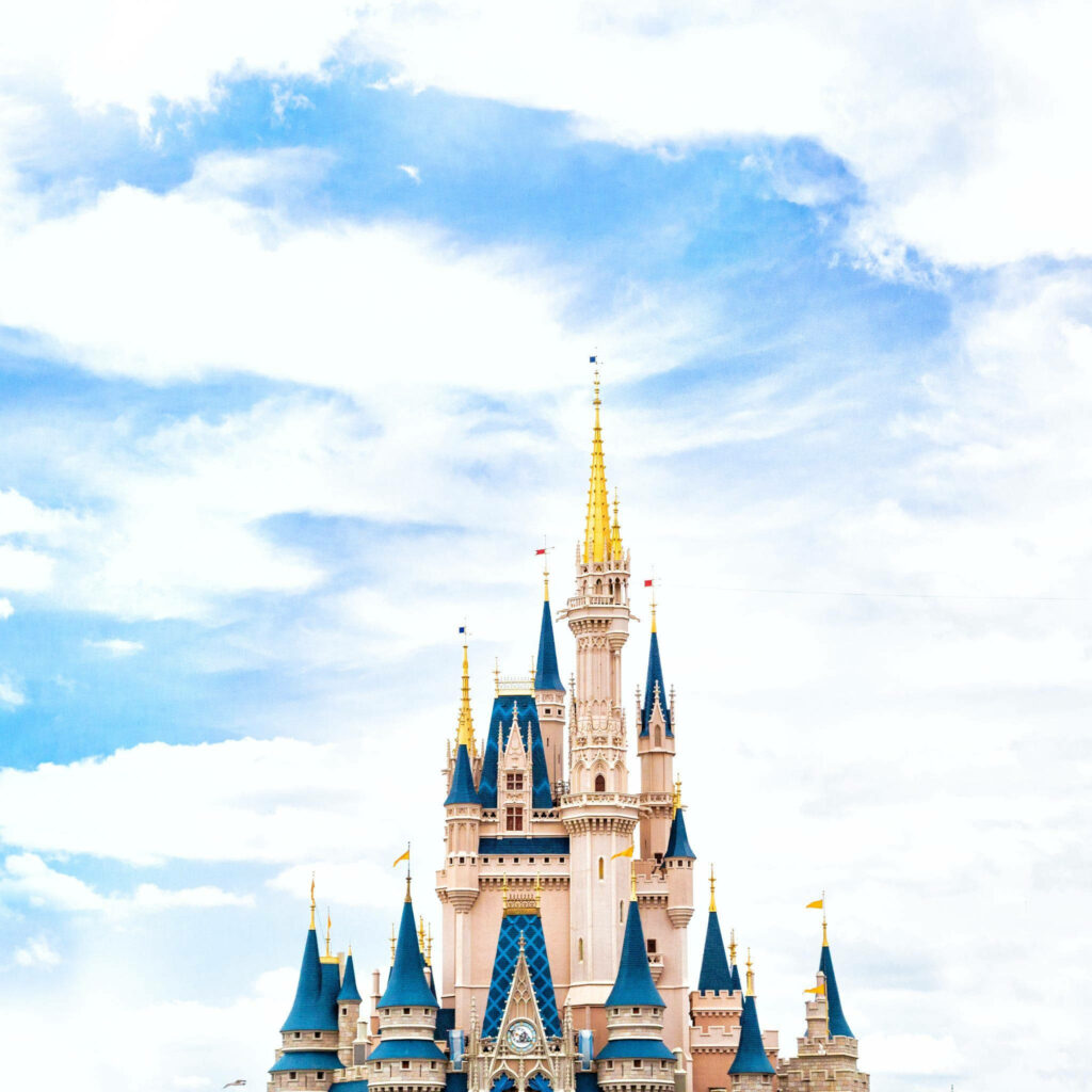 High-definition Disney Castle wallpaper with golden spires and blue rooftops under clear sky