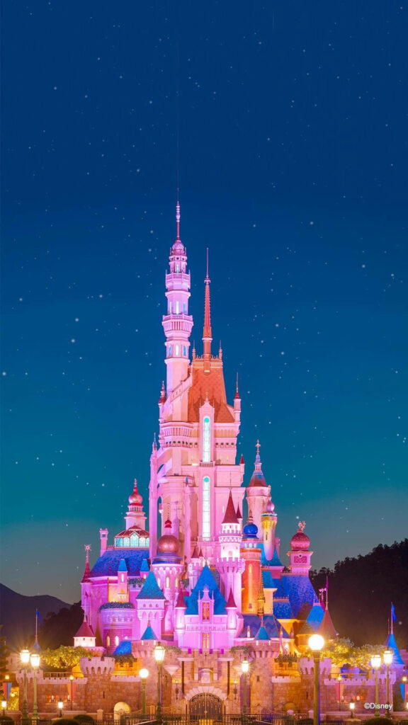 Disney Castle wallpaper glowing with pastel lights under a starry night sky fairy tale background
