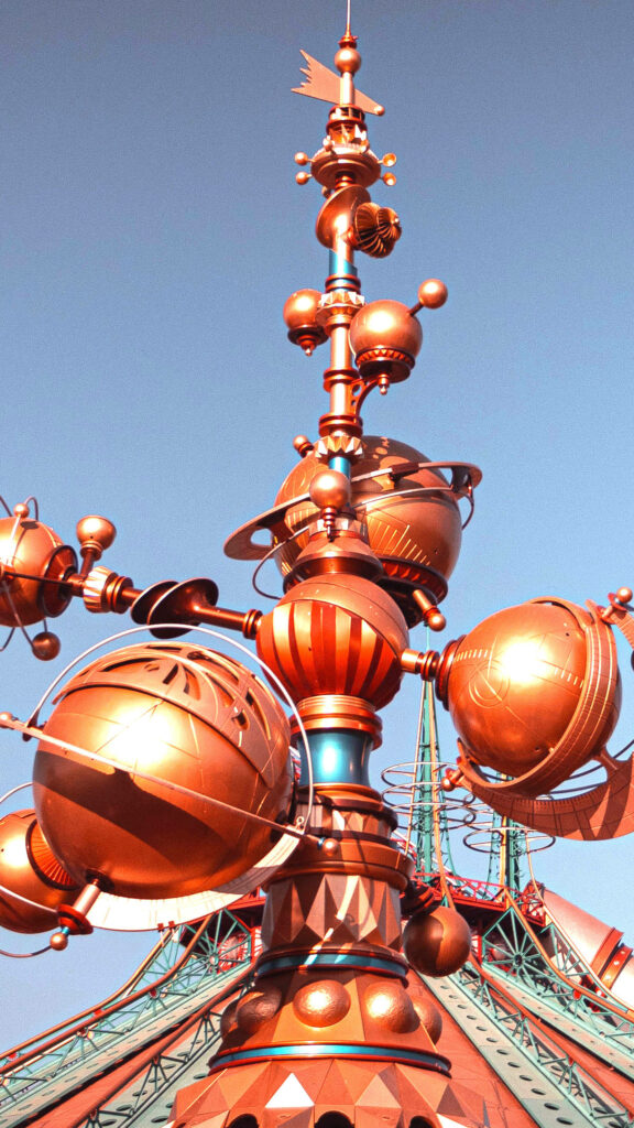 Disneyland Tomorrowland futuristic bronze copper orbs metal structures under clear blue sky wallpaper