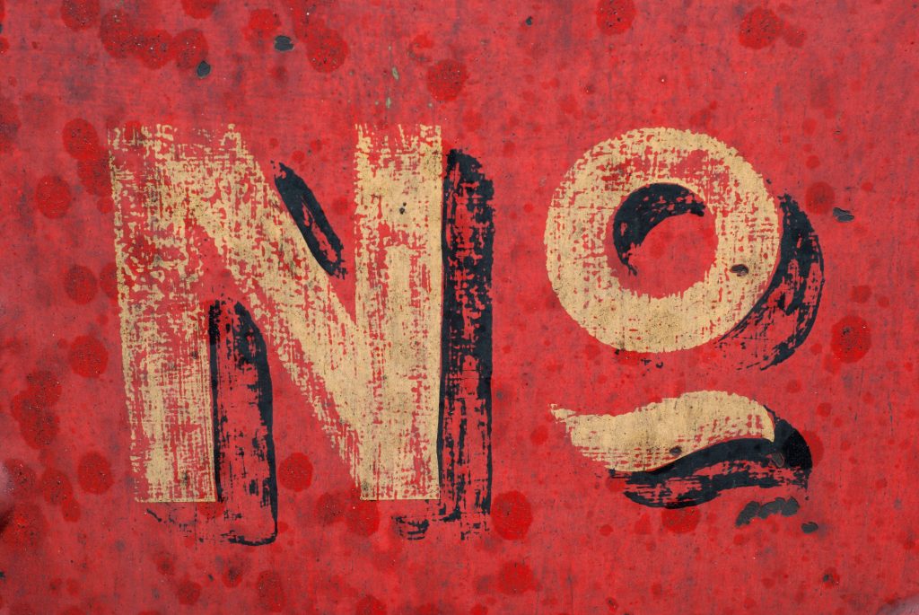 Distressed wallpaper with weathered typography on vivid red paint-splattered industrial background