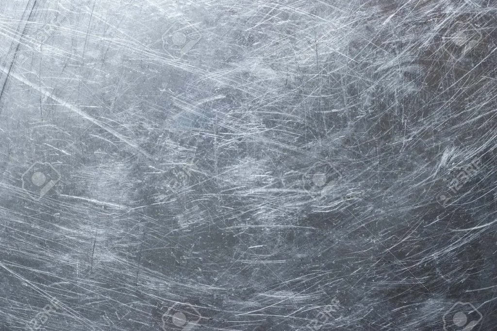 Close-up of distressed industrial metal texture with chaotic scratches in cool gray tones Wallpaper