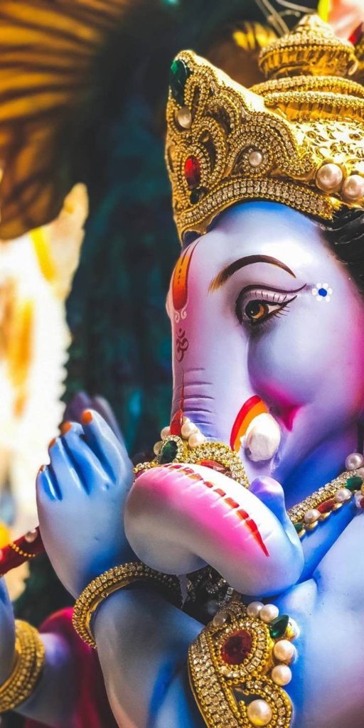Close-up mobile wallpaper of Lord Krishna with blue skin and jeweled crown playing flute