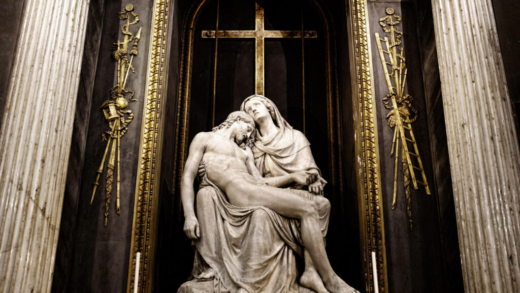 The Divine Duo: Jesus and Mary Embracing in the Pietà Statue - A Heavenly Laptop Wallpaper