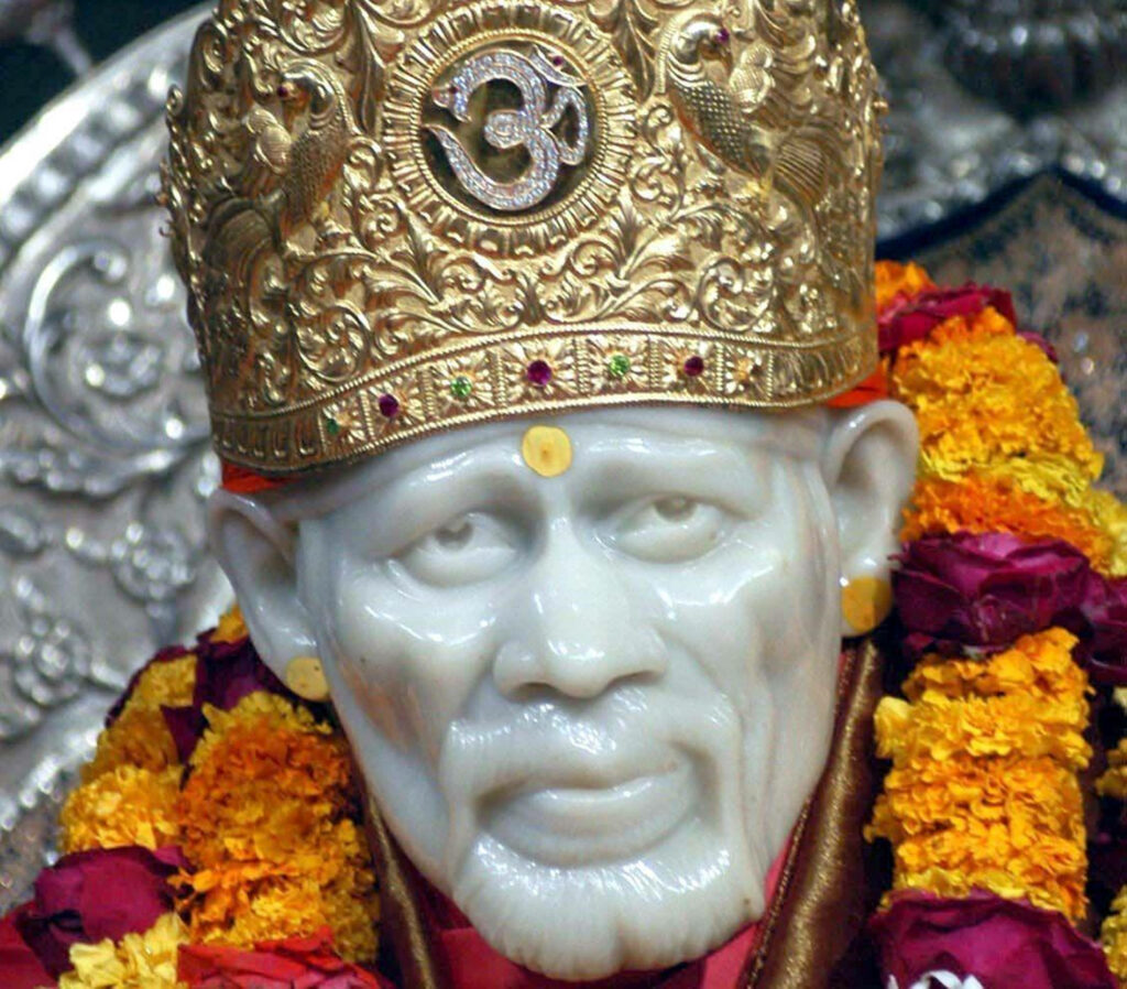 Radiant Statue of Sai Baba: Gilded Crown, Luminous Skin, and Blossoms - Mesmerizing 4k Background Wallpaper
