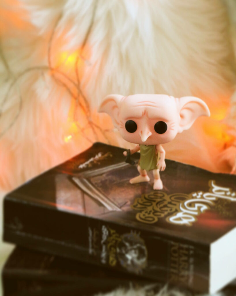 Dobby The Elf Funko Pop on Harry Potter book cozy soft light magical whimsical wallpaper background