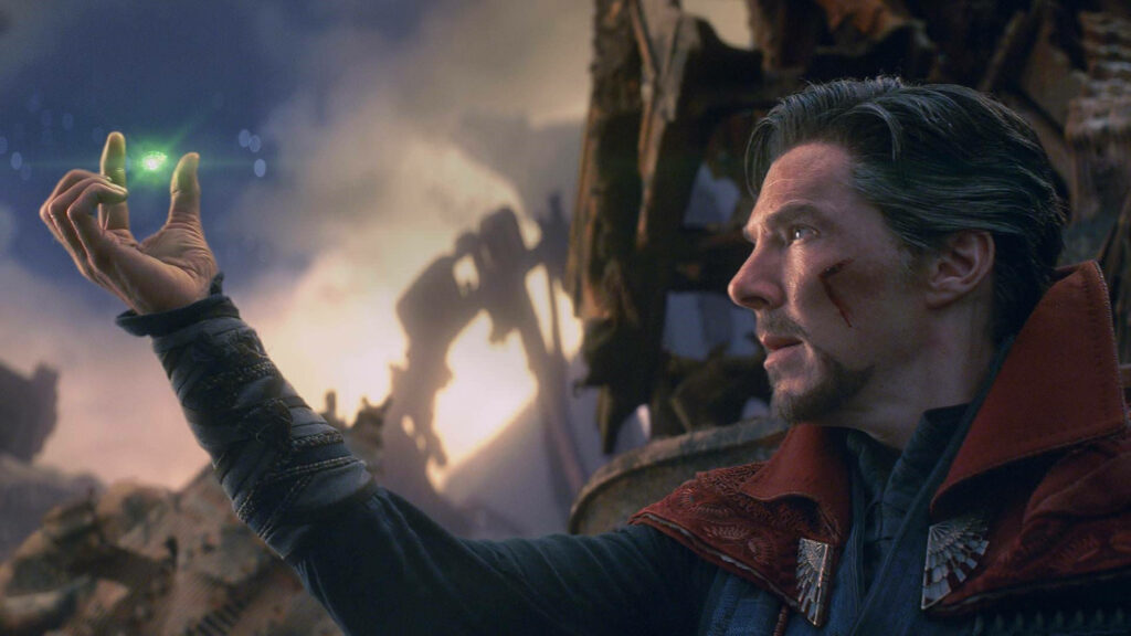 Doctor Strange holding glowing Time Stone in battle-worn costume with dramatic post-apocalyptic backdrop Wallpaper