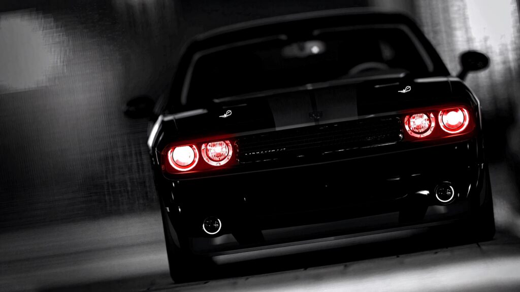 Dodge Challenger rear view with glowing red tail lights against dark cityscape noir wallpaper