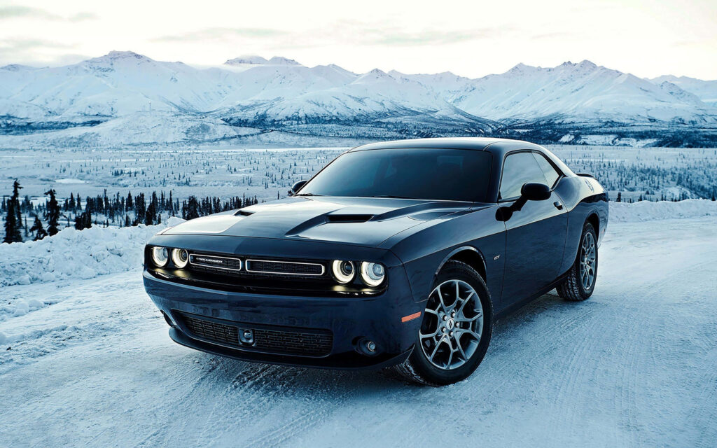 Dodge Hellcat driving through snowy mountain landscape 4K wallpaper background high resolution