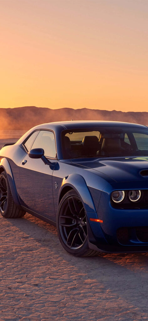 Blue Dodge Hellcat on desert terrain at sunset with warm light highlighting its sleek design Wallpaper
