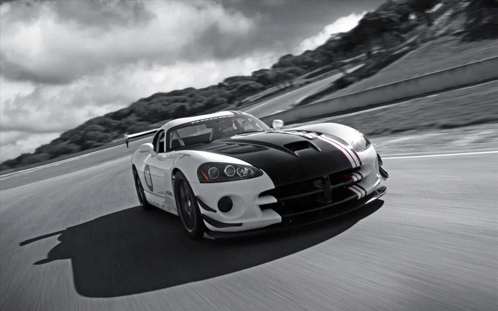 Black and white Dodge Viper racing on track with bold stripes and dramatic landscape background Wallpaper
