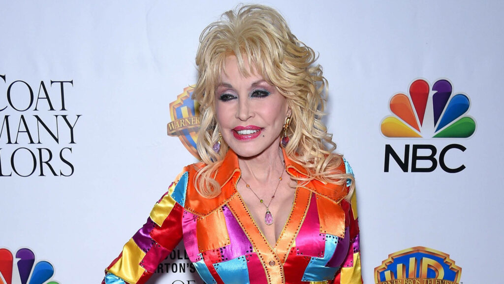 Dolly Parton vibrant multicolored dress NBC movie backdrop iconic celebrity high-resolution wallpaper