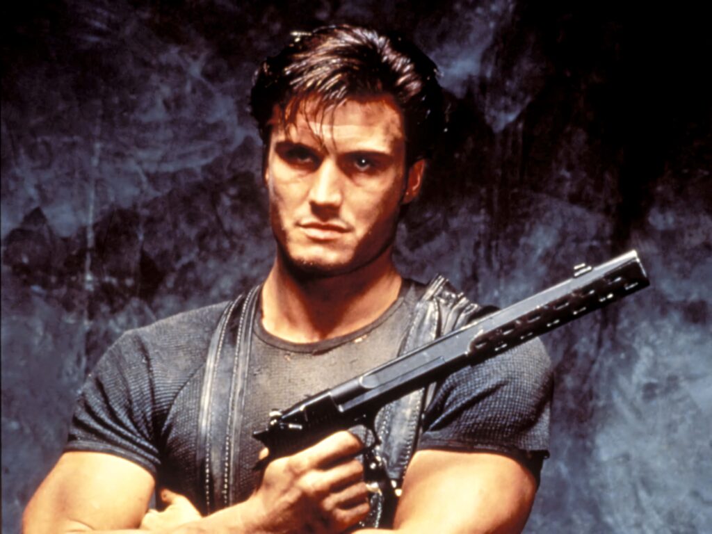 Dolph Lundgren intense pose gripping weapon muscular build dark gritty action wallpaper background