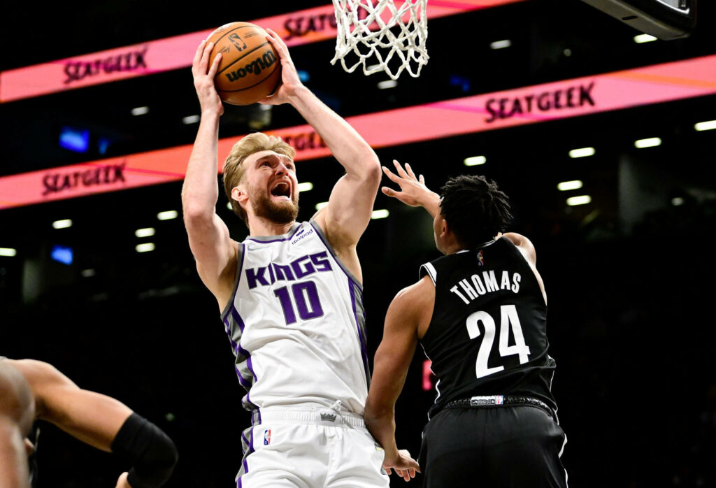Domantas Sabonis Sacramento Kings dunking over Thomas Brooklyn Nets intense basketball action Wallpaper