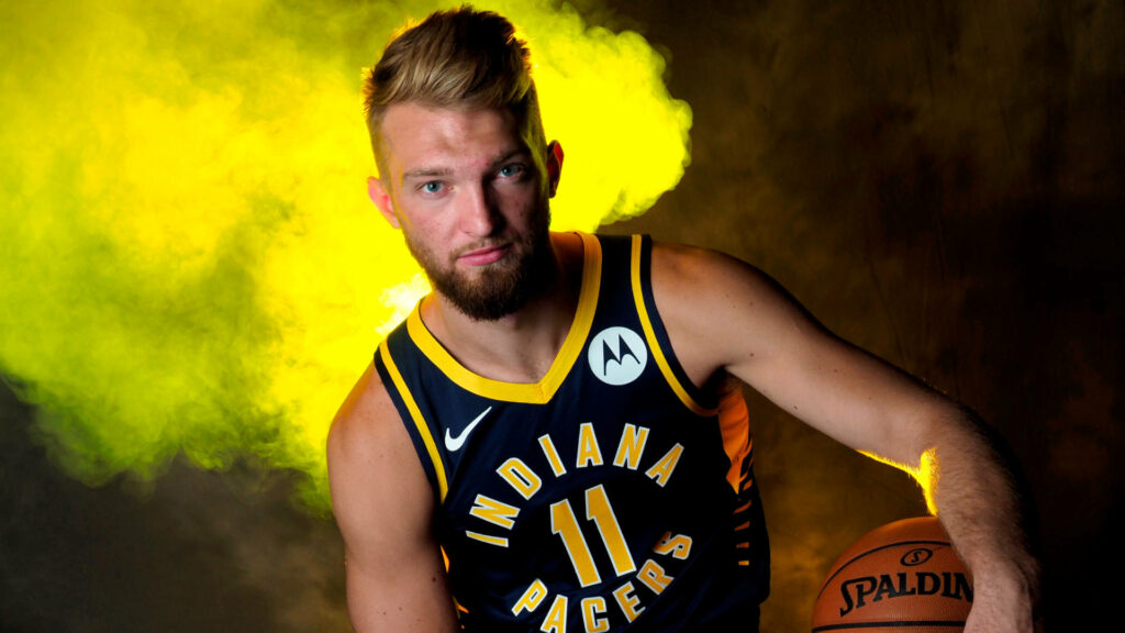 Domantas Sabonis in Indiana Pacers jersey holding basketball with yellow smoke background wallpaper