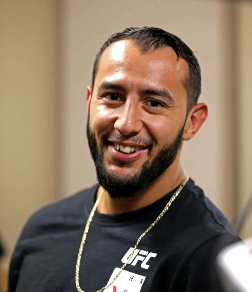Dominick Reyes smiling in black UFC shirt with gold chain MMA fighter wallpaper background