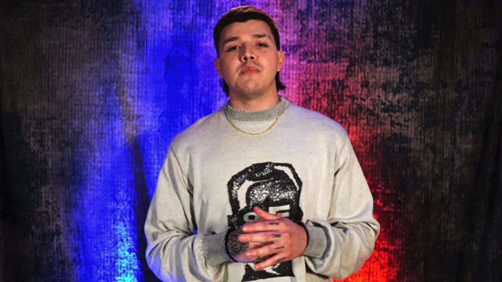 Dominik Mysterio portrait wallpaper vibrant red blue background graphic sweater gold chain