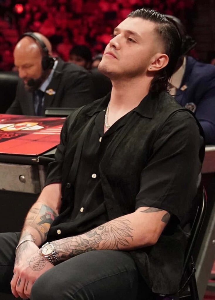Dominik Mysterio ringside with red lights tattoos intense wrestling event wallpaper background