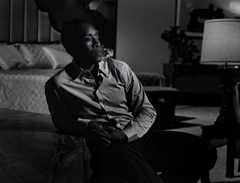 Don Cheadle black and white portrait sitting on bed thoughtful expression elegant room background Wallpaper