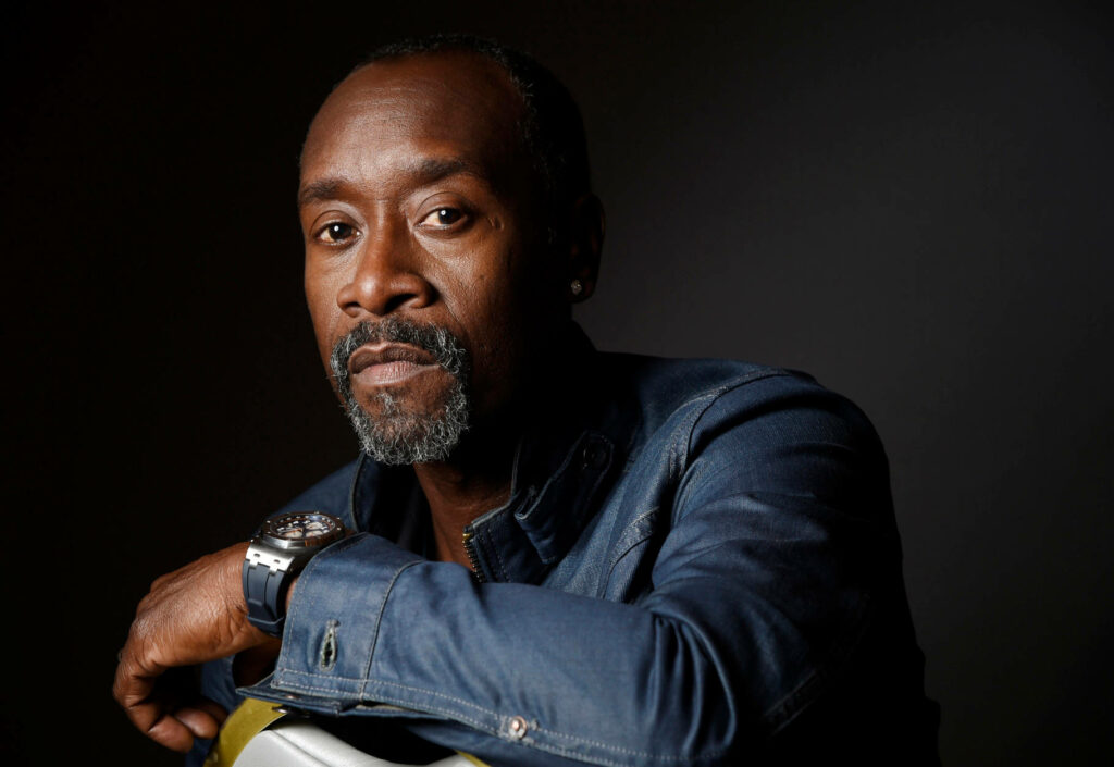 Don Cheadle in blue denim jacket with moustache and goatee against dark background lighting Wallpaper