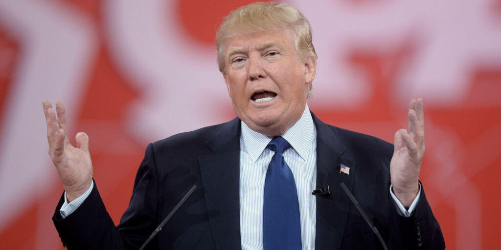 Donald Trump speaking with expressive gesture on bold red background political wallpaper