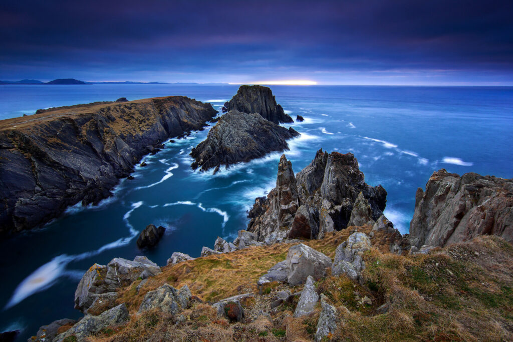Donegal Ireland rugged coastline with dramatic stone cliffs and moody sky over deep blue sea wallpaper