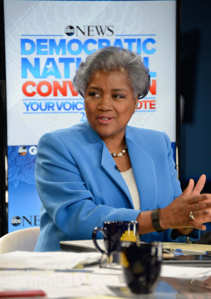 Donna Brazile in blue blazer discussing politics on news set with Democratic National Convention backdrop Wallpaper