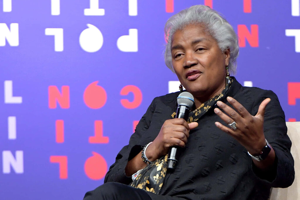 Donna Brazile speaking with microphone colorful modern backdrop bold text dynamic conversation Wallpaper