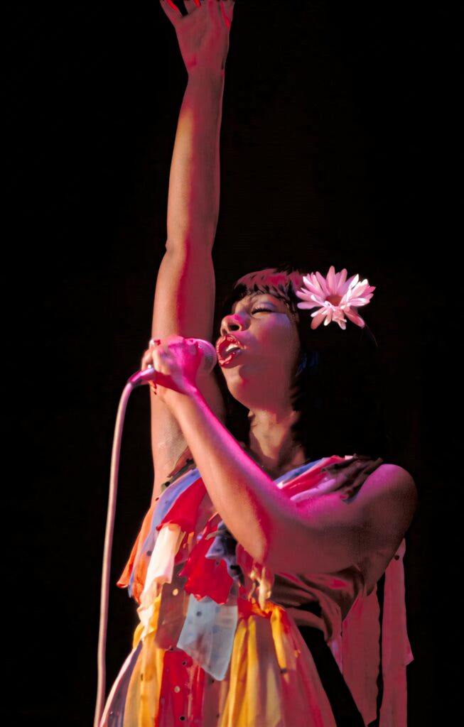 Donna Summer vibrant live performance with red pink lighting floral accessory dynamic outfit Wallpaper