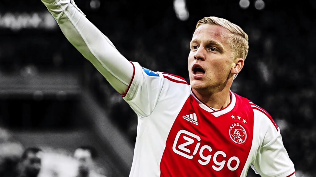 Donny van de Beek in Ajax red and white jersey raising arm spotlight on focused face background blur Wallpaper