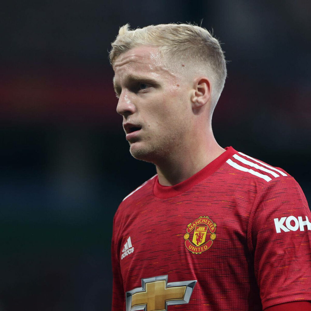 Donny van de Beek in Manchester United red kit thoughtful profile with blurred stadium background Wallpaper