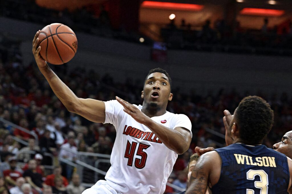 Donovan Mitchell drives to basket in Louisville jersey during intense basketball game action shot Wallpaper