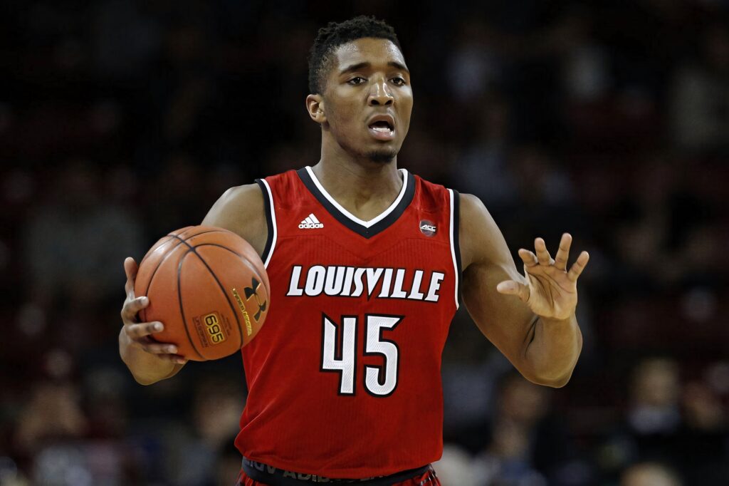 Donovan Mitchell in red Louisville uniform dribbling basketball showing focus and athleticism Wallpaper
