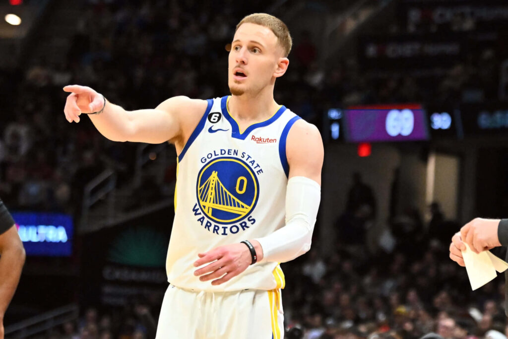 Donte DiVincenzo Golden State Warriors mid-game gesture white blue jersey intense basketball arena Wallpaper