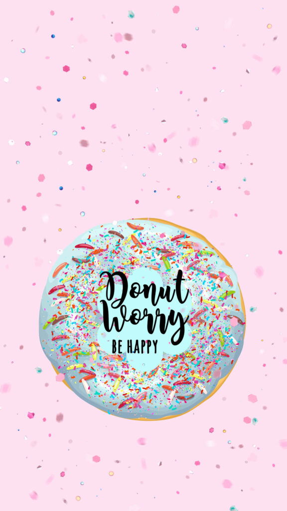 Colorful donut with sprinkles and Donut Worry Be Happy text on soft pink wallpaper background